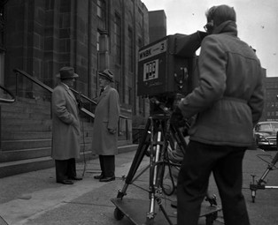 A WNBK camera operator and reporter outside police headquarters.